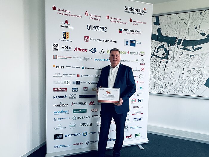 Kay Früchtling vor dem Aktionärsbanner {f:if(condition:'Süderelbe AG',then:' | Bild: © Süderelbe AG',else:'')