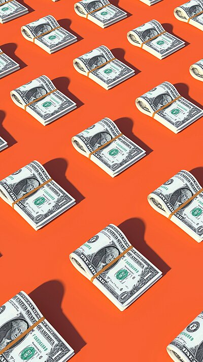 | Bild: © Alexander Mils / Unsplash Symbolbild Geldscheine auf orangenem Untergrund {f:if(condition:'Alexander Mils',then:' | Bild: © Alexander Mils',else:'')